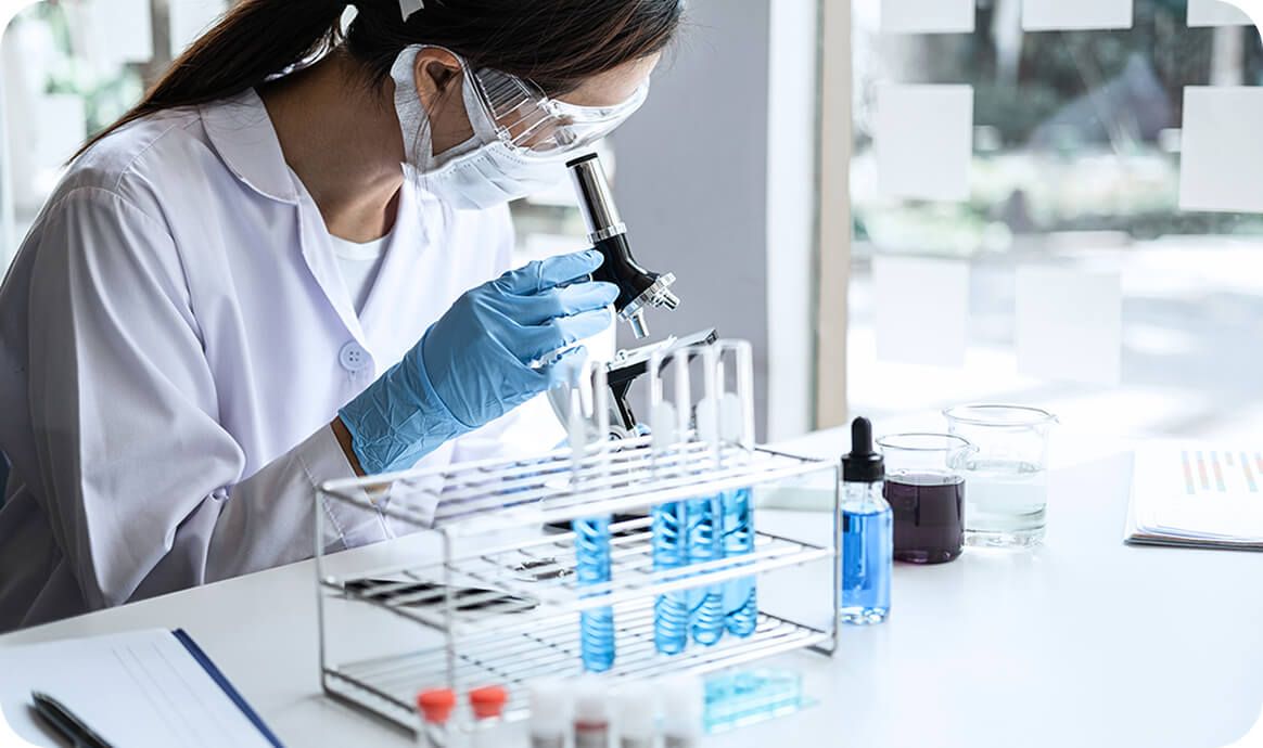 Scientist with microscope and test tubes