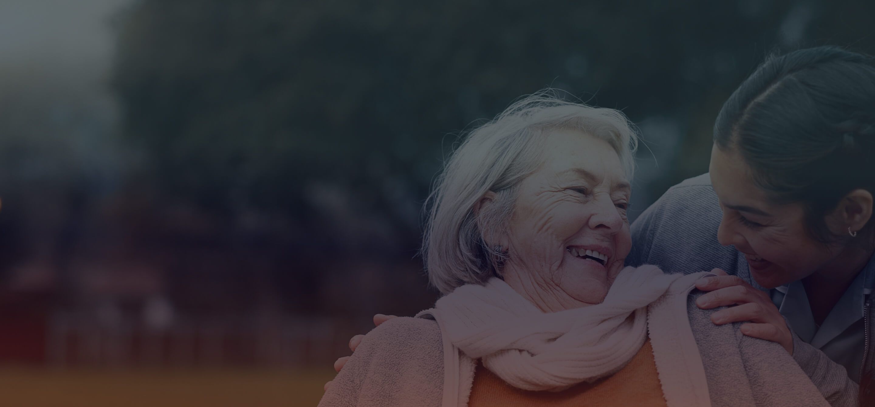 A young woman is smiling at an older woman