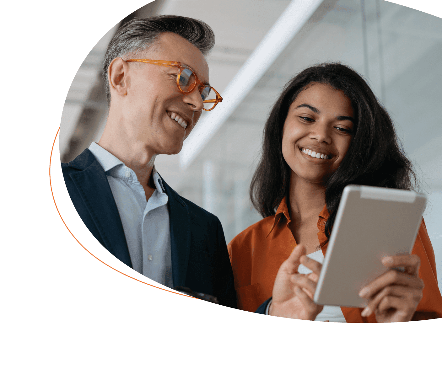 Man and woman smiling while looking at a tablet