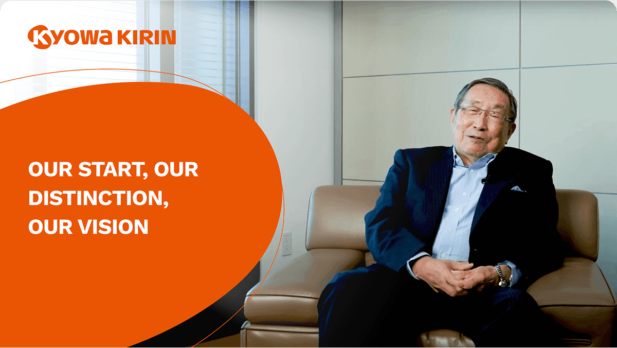 Chairman Aramaki is seated, looking toward the camera